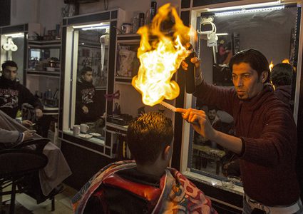حلاق فلسطيني يحلق لزبائنه بالنار