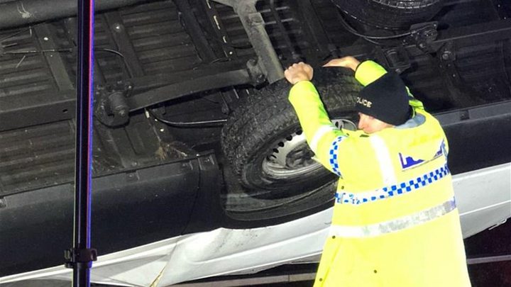 بالصور- شرطي ينقذ سيارة من الوقوع عن الجسر باستخدام يديه!