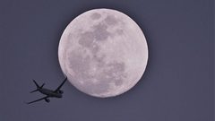 كمنجاتي" يعزف وطائرة تطير على خلفية القمر العملاق