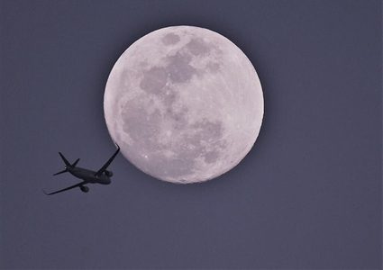 كمنجاتي" يعزف وطائرة تطير على خلفية القمر العملاق
