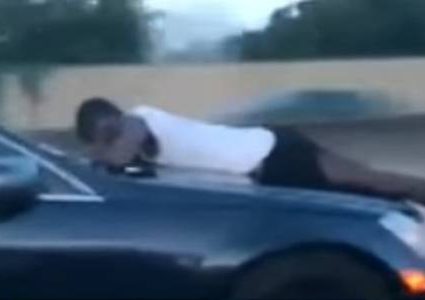 رجل يحاول منع طليقته من قيادة السيارة ويتعلق بزجاجها!