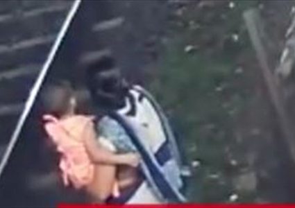 حملت طفلتها بين يديها وقفزت أمام قطار!