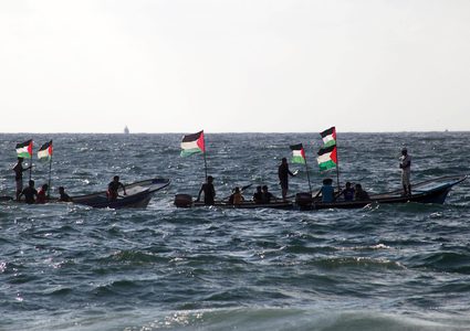 فلسطينيون يركبون قوارب صيد خلال مسيرة لكسر الحصار الإسرائيلي على قطاع غزة ، في البحر في مدينة غزة