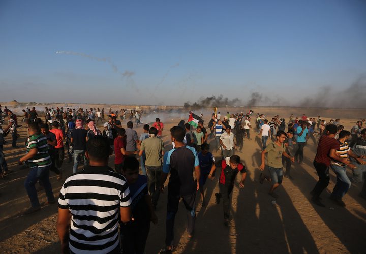 متظاهرون فلسطينيون يتجمعون خلال اشتباكات مع القوات الإسرائيلية في مسيرات العودة حيث يطالب الفلسطينيون بحق العودة إلى وطنهم على الحدود بين إسرائيل وغزة ، في خان يونس جنوب قطاع غزة