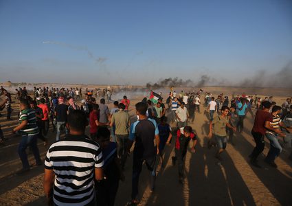 متظاهرون فلسطينيون يتجمعون خلال اشتباكات مع القوات الإسرائيلية في مسيرات العودة حيث يطالب الفلسطينيون بحق العودة إلى وطنهم على الحدود بين إسرائيل وغزة ، في خان يونس جنوب قطاع غزة