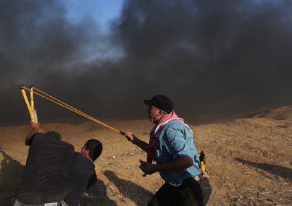 متظاهرون فلسطينيون يتجمعون خلال اشتباكات مع القوات الإسرائيلية في مسيرات العودة حيث يطالب الفلسطينيون بحق العودة إلى وطنهم على الحدود بين إسرائيل وغزة ، في خان يونس جنوب قطاع غزة