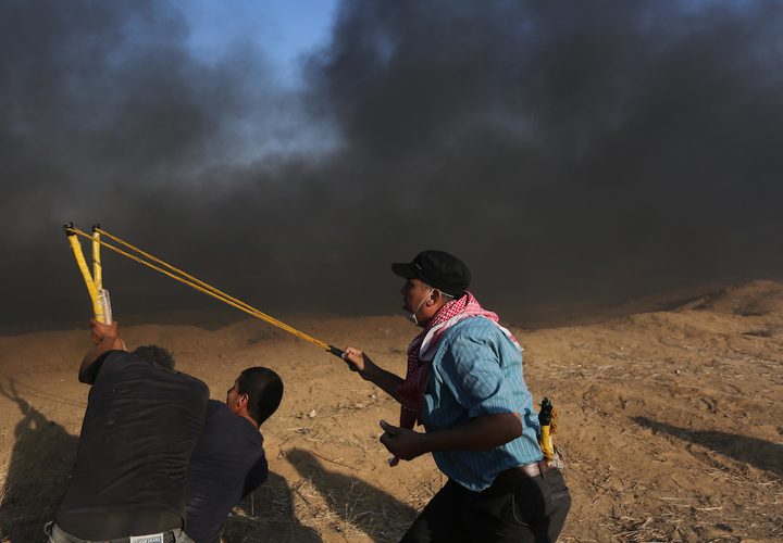 متظاهرون فلسطينيون يتجمعون خلال اشتباكات مع القوات الإسرائيلية في مسيرات العودة حيث يطالب الفلسطينيون بحق العودة إلى وطنهم على الحدود بين إسرائيل وغزة ، في خان يونس جنوب قطاع غزة