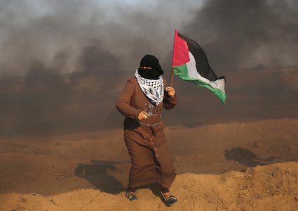 متظاهرون فلسطينيون يتجمعون خلال اشتباكات مع القوات الإسرائيلية في مسيرات العودة حيث يطالب الفلسطينيون بحق العودة إلى وطنهم على الحدود بين إسرائيل وغزة ، في خان يونس جنوب قطاع غزة