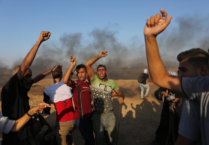 متظاهرون فلسطينيون يتجمعون خلال اشتباكات مع القوات الإسرائيلية في مسيرات العودة حيث يطالب الفلسطينيون بحق العودة إلى وطنهم على الحدود بين إسرائيل وغزة ، في خان يونس جنوب قطاع غزة