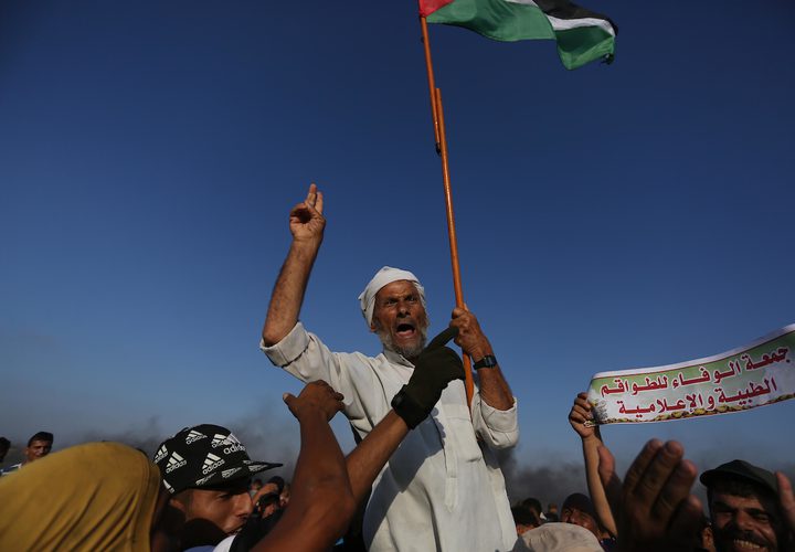 متظاهرون فلسطينيون يتجمعون خلال اشتباكات مع القوات الإسرائيلية في مسيرات العودة حيث يطالب الفلسطينيون بحق العودة إلى وطنهم على الحدود بين إسرائيل وغزة ، في خان يونس جنوب قطاع غزة