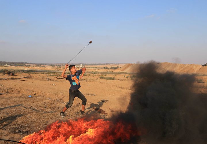 متظاهرون فلسطينيون يتجمعون خلال اشتباكات مع القوات الإسرائيلية في مسيرات العودة حيث يطالب الفلسطينيون بحق العودة إلى وطنهم على الحدود بين إسرائيل وغزة ، في خان يونس جنوب قطاع غزة