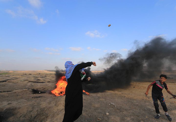 متظاهرون فلسطينيون يتجمعون خلال اشتباكات مع القوات الإسرائيلية في مسيرات العودة حيث يطالب الفلسطينيون بحق العودة إلى وطنهم على الحدود بين إسرائيل وغزة ، في خان يونس جنوب قطاع غزة