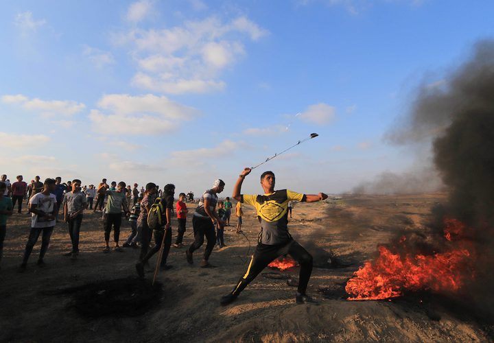 متظاهرون فلسطينيون يتجمعون خلال اشتباكات مع القوات الإسرائيلية في مسيرات العودة حيث يطالب الفلسطينيون بحق العودة إلى وطنهم على الحدود بين إسرائيل وغزة ، في خان يونس جنوب قطاع غزة