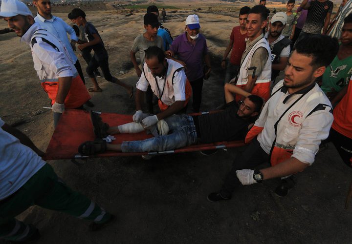 متظاهرون فلسطينيون يتجمعون خلال اشتباكات مع القوات الإسرائيلية في مسيرات العودة حيث يطالب الفلسطينيون بحق العودة إلى وطنهم على الحدود بين إسرائيل وغزة ، في خان يونس جنوب قطاع غزة