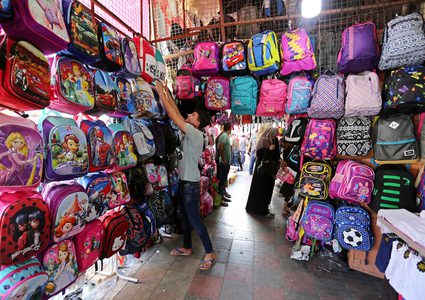 فلسطينيون يتسوقون في أحد الأسواق خلال الإعداد للسنة الدراسية الجديدة في مدينة غزة