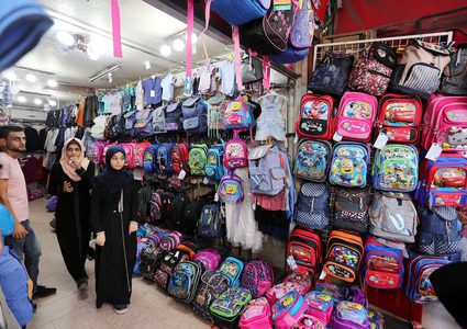 فلسطينيون يتسوقون في أحد الأسواق خلال الإعداد للسنة الدراسية الجديدة في مدينة غزة