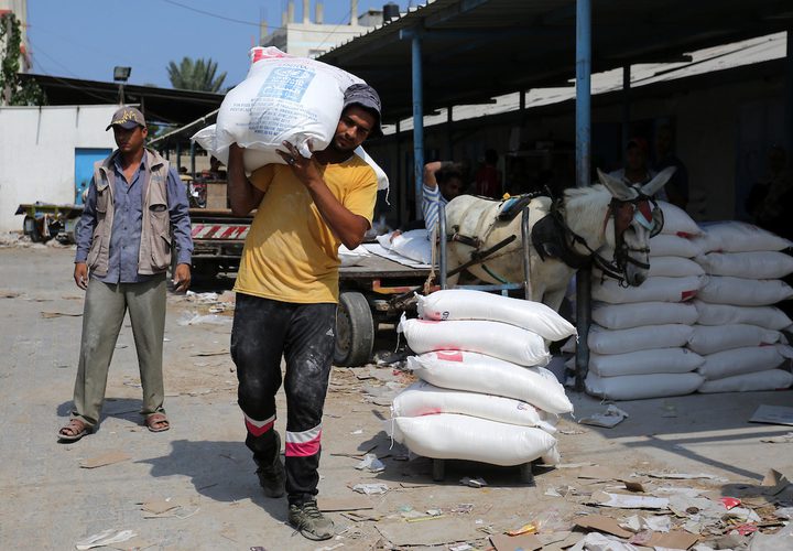 فلسطينيون يسيرون في أحد شوارع مخيم الشاطئ للاجئين ، بعد أن أوقفت الولايات المتحدة يوم الجمعة كل التمويل لأونروا