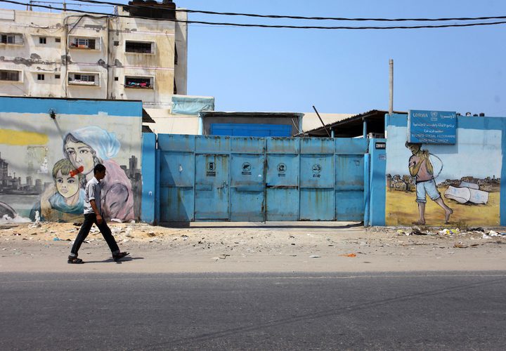 فلسطينيون يسيرون في أحد شوارع مخيم الشاطئ للاجئين ، بعد أن أوقفت الولايات المتحدة يوم الجمعة كل التمويل لأونروا