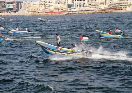 فلسطينيون يركبون قوارب صيد خلال مسيرة لكسر الحصار الإسرائيلي على قطاع غزة ، في البحر في مدينة غزة .