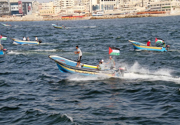 فلسطينيون يركبون قوارب صيد خلال مسيرة لكسر الحصار الإسرائيلي على قطاع غزة ، في البحر في مدينة غزة .