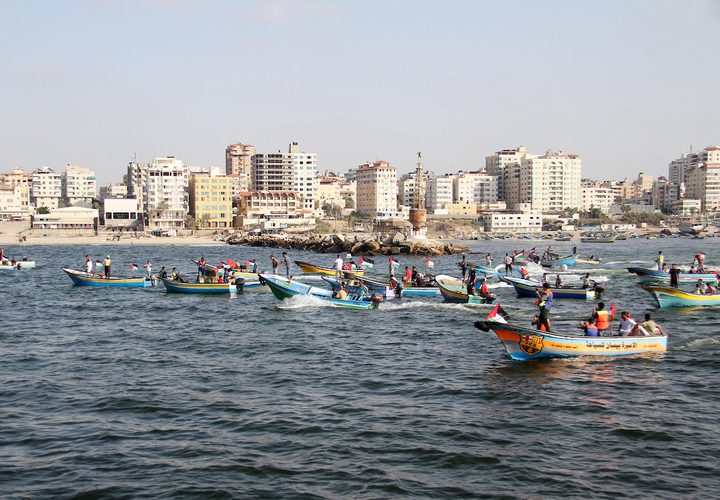 فلسطينيون يركبون قوارب صيد خلال مسيرة لكسر الحصار الإسرائيلي على قطاع غزة ، في البحر في مدينة غزة .