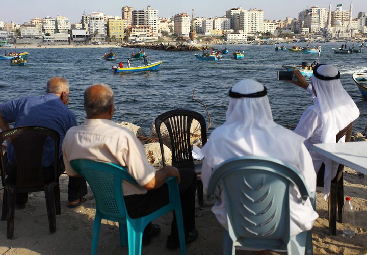 فلسطينيون يركبون قوارب صيد خلال مسيرة لكسر الحصار الإسرائيلي على قطاع غزة ، في البحر في مدينة غزة .