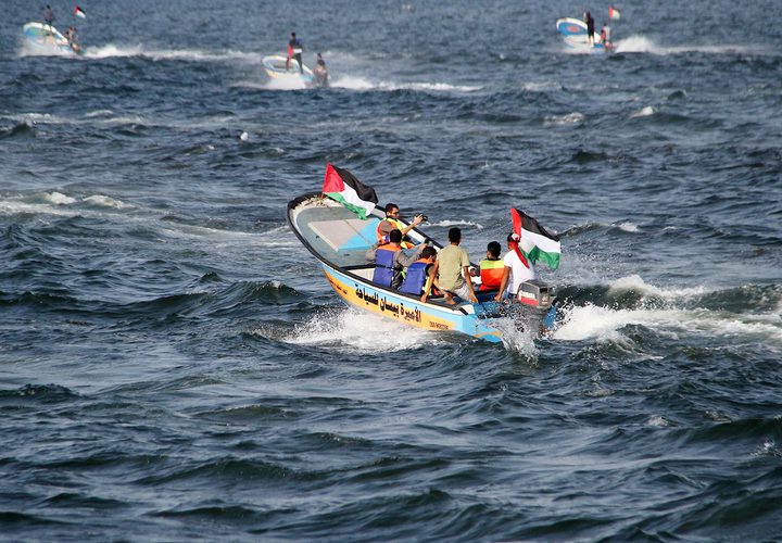 فلسطينيون يركبون قوارب صيد خلال مسيرة لكسر الحصار الإسرائيلي على قطاع غزة ، في البحر في مدينة غزة .