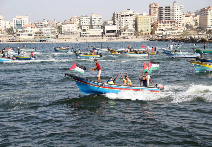 فلسطينيون يركبون قوارب صيد خلال مسيرة لكسر الحصار الإسرائيلي على قطاع غزة ، في البحر في مدينة غزة .