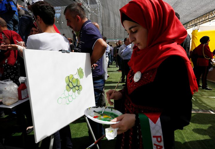 الفلسطينيون يعرضون العنب خلال مهرجان العنب الفلسطيني في قرية حلحول ، بالقرب من مدينة الخليل في الضفة الغربية