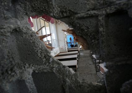 فلسطينيون يتفقدون فصلاً من مدرسة تديرها الأمم المتحدة تضررت جراء القصف الإسرائيلي في اليوم السابق ، في خان يونس في جنوب قطاع غزة في 15 سبتمبر 2018.