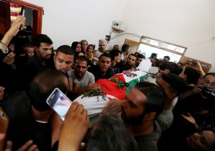 أقارب الفلسطيني علاء أبو عاصي الذي قُتل في غارة جوية إسرائيلية على الحدود بين إسرائيل وغزة ، حداد خلال جنازته في خان يونس في جنوب قطاع غزة في 19 سبتمبر 2018.