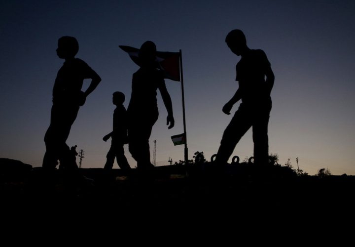 متظاهرون فلسطينيون يتجمعون حول العلم الفلسطيني في قرية خان الأحمر البدوية في الضفة الغربية المحتلة ضد خطة إسرائيل لهدم القرية في 26 سبتمبر 2018.