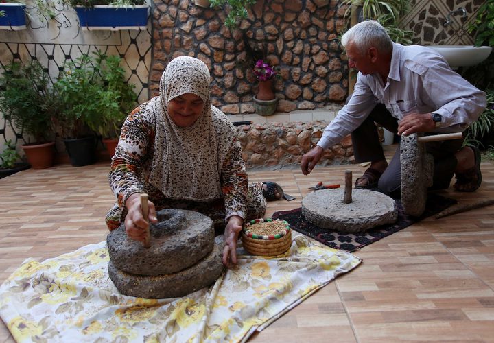 سيدة فلسطينية تطحن القمح بواسطة مطحنة حجرية داخل منزلها، في قرية جلبون بالقرب من مدينة جنين في الضفة الغربية.