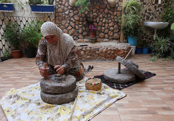 سيدة فلسطينية تطحن القمح بواسطة مطحنة حجرية داخل منزلها، في قرية جلبون بالقرب من مدينة جنين في الضفة الغربية.