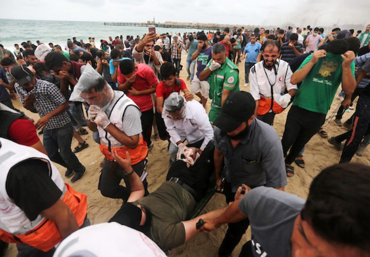 متظاهرون فلسطينيون يجتمعون خلال اشتباكات مع القوات الإسرائيلية في مظاهرة ضد الحصار الإسرائيلي على قطاع غزة ، على طول الحاجز البحري لغزة على الحدود البحرية مع إسرائيل بالقرب من كيبوتس زكيم ، شمال بيت لاهيا في شمال قطاع غزة في 1 أكتوبر 2018.