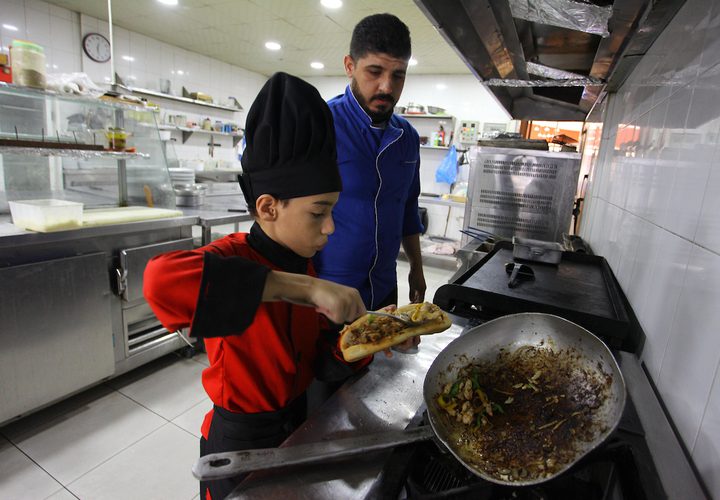 محمد أبو ندا (12 عاماً) طباخ فلسطيني، يطبخ الوجبات الغربية في مطعم بمدينة غزة.