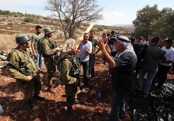 جنود الاحتلال يحاولون منع المزارعين الفلسطينيين من الوصول إلى مزارعهم لحصد الزيتون في قرية الساوية بالقرب من مستوطنةرحيليم، في محافظة نابلس.