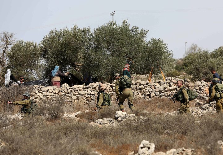 جنود الاحتلال يحاولون منع المزارعين الفلسطينيين من الوصول إلى مزارعهم لحصد الزيتون في قرية الساوية بالقرب من مستوطنةرحيليم، في محافظة نابلس.