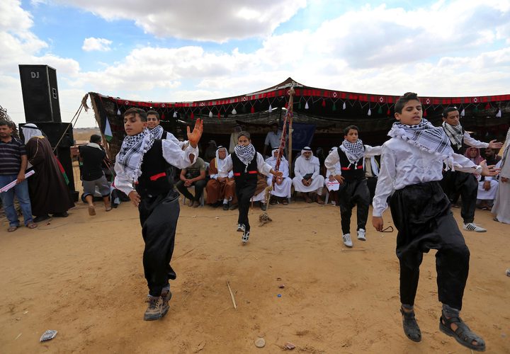 فلسطينيون يؤدون الرقص التقليدي خلال مهرجان تراثي على الحدود بين إسرائيل وغزة.