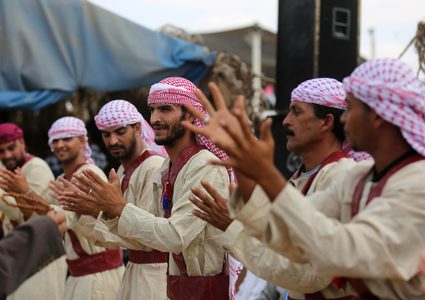 فلسطينيون يؤدون الرقص التقليدي خلال مهرجان تراثي على الحدود بين إسرائيل وغزة.