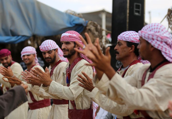 فلسطينيون يؤدون الرقص التقليدي خلال مهرجان تراثي على الحدود بين إسرائيل وغزة.