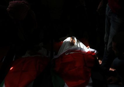 مشيعون فلسطينيون يحملون جثث ثلاثة فتيان فلسطينيين قتلوا في غارة جوية إسرائيلية على قطاع غزة خلال جنازتهم في دير البلح وسط قطاع غزة في 29 أكتوبر عام 2018.