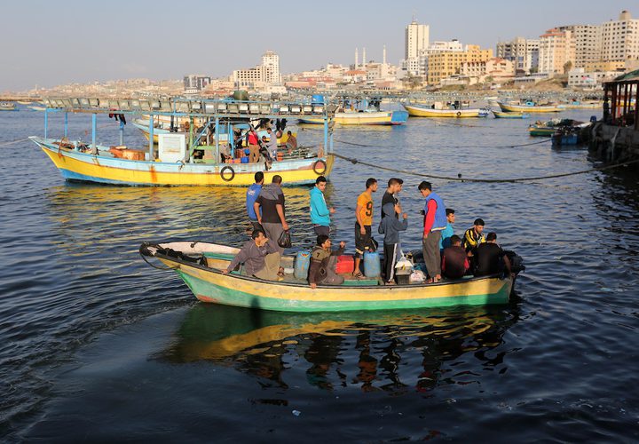 صيادون فلسطينيون يعملون على قوارب الصيد الخاصة بهم في البحر في الميناء البحري في مدينة غزة.