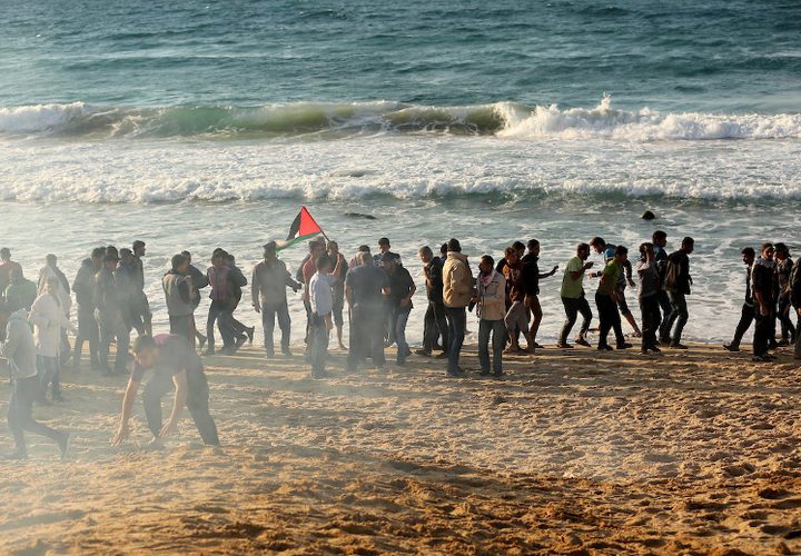 متظاهرون فلسطينيون يجتمعون خلال اشتباكات مع القوات الإسرائيلية في مظاهرة ضد الحصار الإسرائيلي على قطاع غزة، على طول الحاجز البحري لغزة على الحدود البحرية مع إسرائيل بالقرب من كيبوتس زيكيم، شمال بيت لاهيا في شمال قطاع غزة