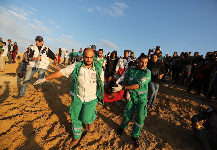 متظاهرون فلسطينيون يجتمعون خلال اشتباكات مع القوات الإسرائيلية في مظاهرة ضد الحصار الإسرائيلي على قطاع غزة، على طول الحاجز البحري لغزة على الحدود البحرية مع إسرائيل بالقرب من كيبوتس زيكيم، شمال بيت لاهيا في شمال قطاع غزة