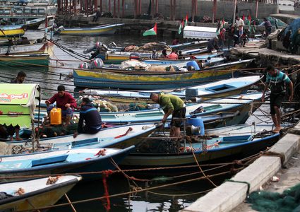 صيادون فلسطينيون يعملون على قوارب الصيد الخاصة بهم في البحر في الميناء البحري في مدينة غزة في15 نوفمبر 2018.