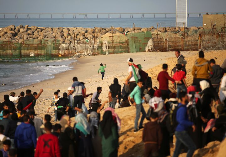 متظاهرون فلسطينيون يجتمعون خلال اشتباكات مع القوات الإسرائيلية في مظاهرة ضد الحصار الإسرائيلي على قطاع غزة، على طول الحاجز البحري لغزة على الحدود البحرية مع إسرائيل بالقرب من كيبوتس زيكيم، شمال بيت لاهيا في شمال قطاع غزة