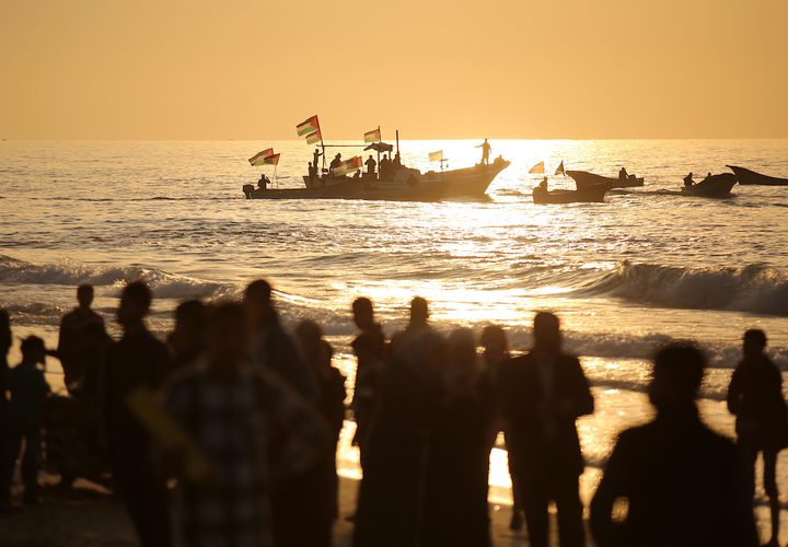 متظاهرون فلسطينيون يجتمعون خلال اشتباكات مع القوات الإسرائيلية في مظاهرة ضد الحصار الإسرائيلي على قطاع غزة، على طول الحاجز البحري لغزة على الحدود البحرية مع إسرائيل بالقرب من كيبوتس زيكيم، شمال بيت لاهيا في شمال قطاع غزة