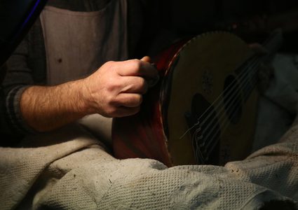 الممرض الفلسطيني علي الحسين (57 عاما) يعمل في ورشته على صناعة العود والآلات الموسيقية في نابلس.