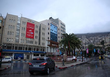 فلسطينيون يسيرون في شارع غمرته المياه في يوم ممطر في المدينة القديمة لمدينة نابلس بالضفة الغربية ، في 8 ديسمبر / كانون الأول 2018.